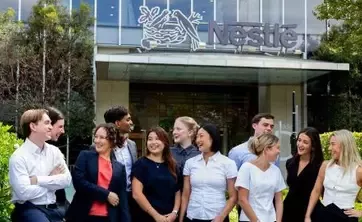 Nestlé team members gathered outside a modern office building